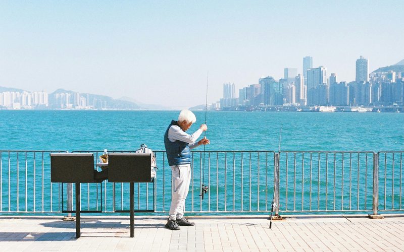 Retired man fishing by waterfront